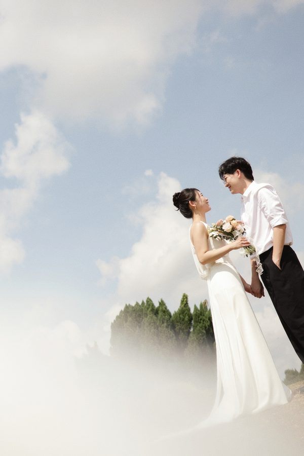 Darren and Jade beneath a cloudy sky, holding hands